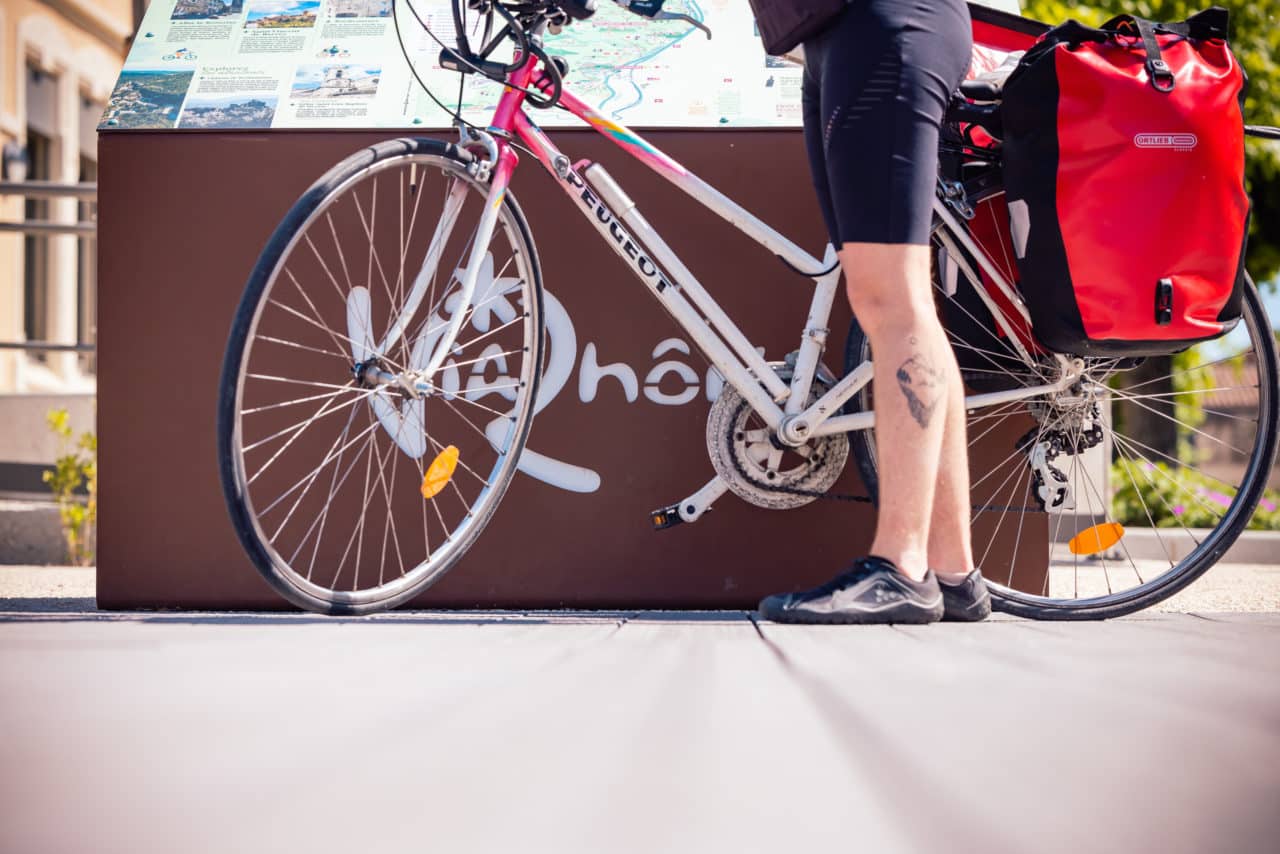 ViaRhôna : parcours à vélo en Sud Ardèche avec une jeune femme arrété devant la carte du territoire