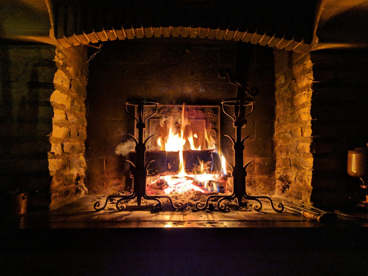 Cheminée avec un agréable feu de bois. Les couleurs de la photo en noir et jaune donne une ambiance agréable au coin du feu un soir de Noël en Ardèche.